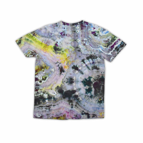 An artisanal ice-dyed t-shirt, its surface a canvas of swirling blues, purples, and chartreuse resembling geode formations, with the text 'dazed' in a stylized, icy lettering at the center.