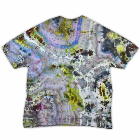 An artisanal ice-dyed t-shirt, its surface a canvas of swirling blues, purples, and chartreuse resembling geode formations, with the text 'dazed' in a stylized, icy lettering at the center.