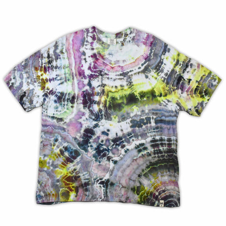 An artisanal ice-dyed t-shirt, its surface a canvas of swirling blues, purples, and chartreuse resembling geode formations, with the text 'dazed' in a stylized, icy lettering at the center.