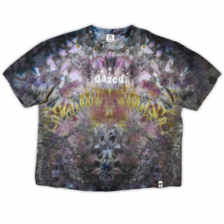 An eye-catching ice-dyed t-shirt showcasing a vibrant explosion of purples, pinks, and grays with a smoky effect around the 'dazed' text featured in the center.