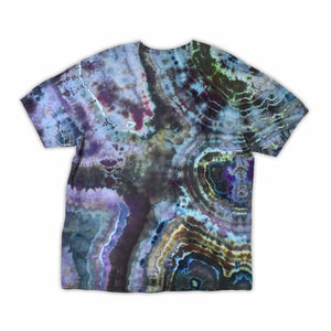 The vibrant patterns of this tie-dye t-shirt are reminiscent of a sliced geode, with bands of blue, purple, and green that encircle the 'dazed' text, which glistens like a quartz inscription.