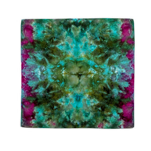 A hand-dyed bandana with an artistic ice dye technique, showcasing a burst of teal and jade, edged with hints of vibrant pink, resembling a blooming underwater flower.