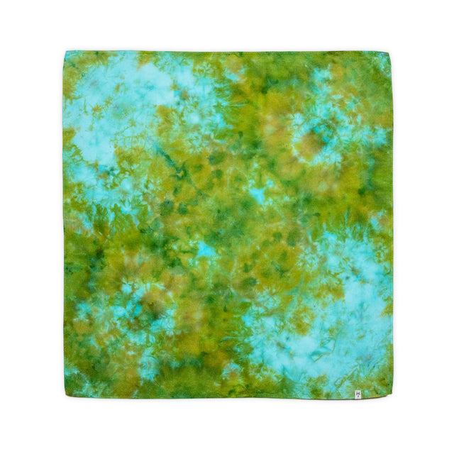 Bandana with an organic ice dye design in various hues of green and blue, giving the impression of a blurred aerial view of a lush forest.
