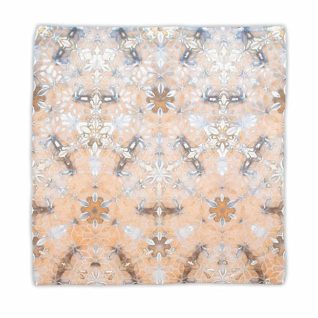 Earth-toned tie-dyed bandana displaying a symmetrical pattern with elements that suggest flowers and stars, in a soft palette of beige, grey, and white.