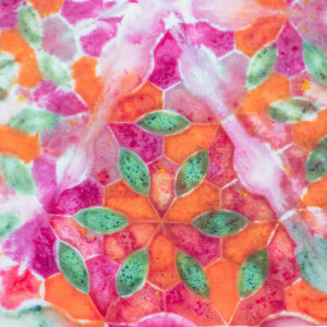 An eye-catching bandana with a tie-dye splash of neon pinks, bright oranges, and leafy greens, forming a pattern resembling a summer garden.