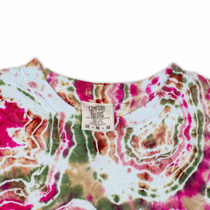 The long sleeve garment features a bold print that resembles cross-sections of gemstones, with rich pinks and greens dominating the design.