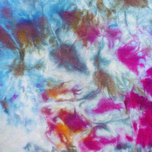 An ice-dyed tank dress with an explosion of color, including bright pinks, deep blues, and earthy browns, creating an abstract floral effect.
