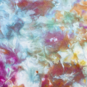 An ice-dyed tank dress with an explosion of color, including bright pinks, deep blues, and earthy browns, creating an abstract floral effect.
