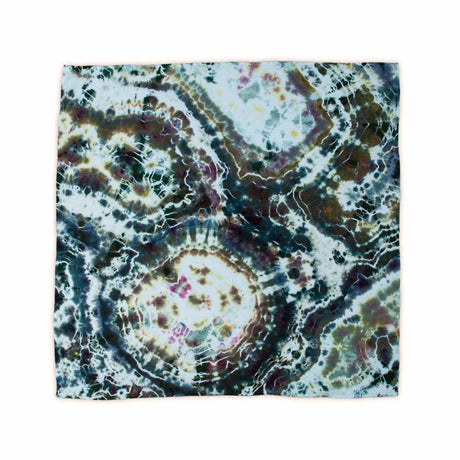 A hand-dyed bandana capturing the essence of mineral formations with its ice dye design, presenting a mix of silvery grey and rustic brown with a network of white veins.