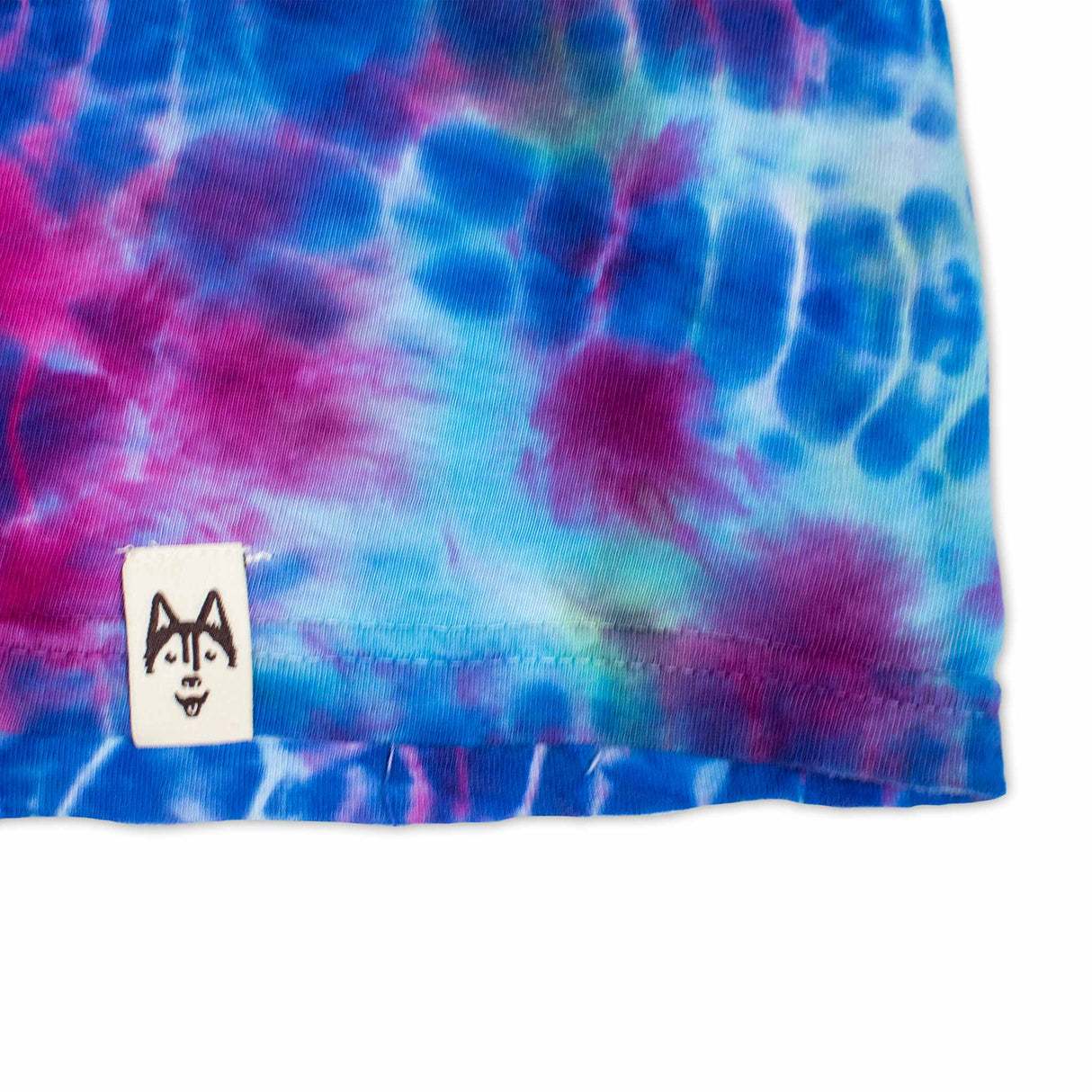 This long sleeve shirt boasts a bold tie-dye pattern with deep blues and bright pinks, reminiscent of a cosmic nebula.