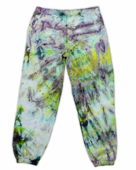 A pair of artistic ice-dyed sweatpants, with a kaleidoscopic effect of electric green, deep violet, and sky blue colors.