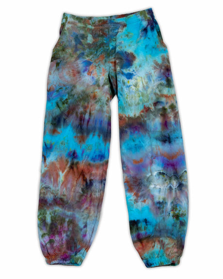 A pair of artistic ice-dyed sweatpants, with a dynamic mix of cobalt, fiery orange, and deep lilac, evoking a sense of abstract expressionism.