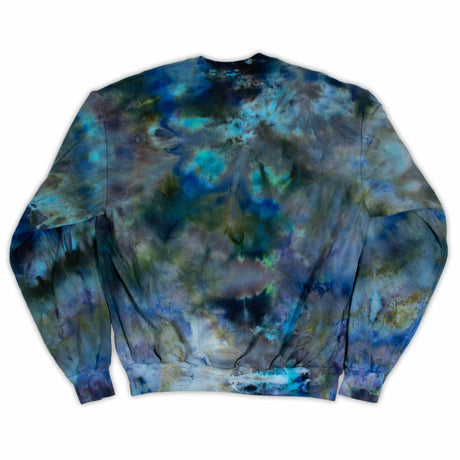 A cozy sweatshirt showcases an ice dye technique with a fusion of deep blues and soft greens, inviting a sense of calm and comfort."