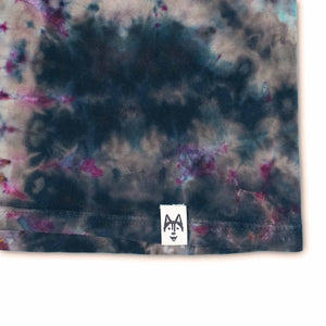 This unique t-shirt boasts a reverse dye effect, displaying a cosmic blend of dark hues with subtle pops of pink and purple against a black and brown backdrop.